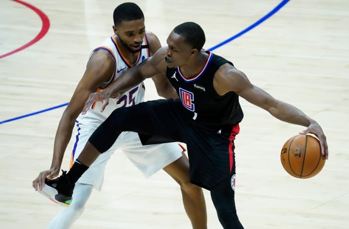 Apr 8, 2021; Los Angeles, California, USA; LA Clippers guard Rajon Rondo (4) keeps the ball away from Phoenix Suns forward Mikal Bridges (25) during the fourth quarter at Staples Center. Mandatory Credit: Robert Hanashiro-USA TODAY Sports